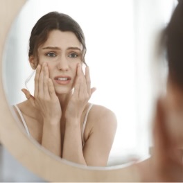 sad woman looking in a mirror